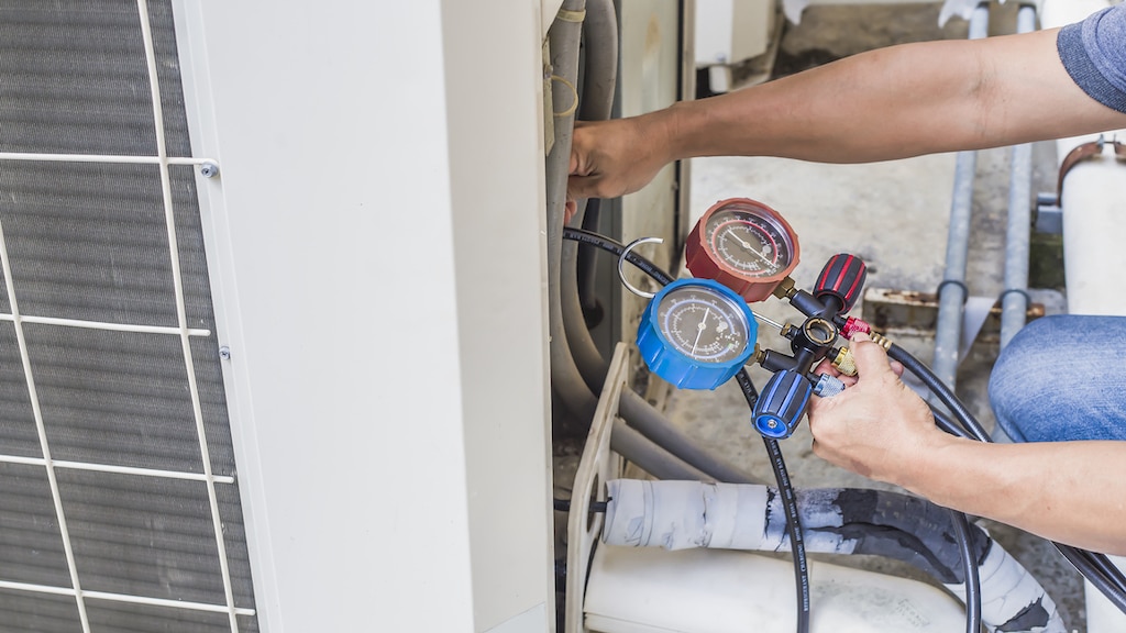 technician checks the operation of the air conditioner. Emergency Heating and Cooling Services 