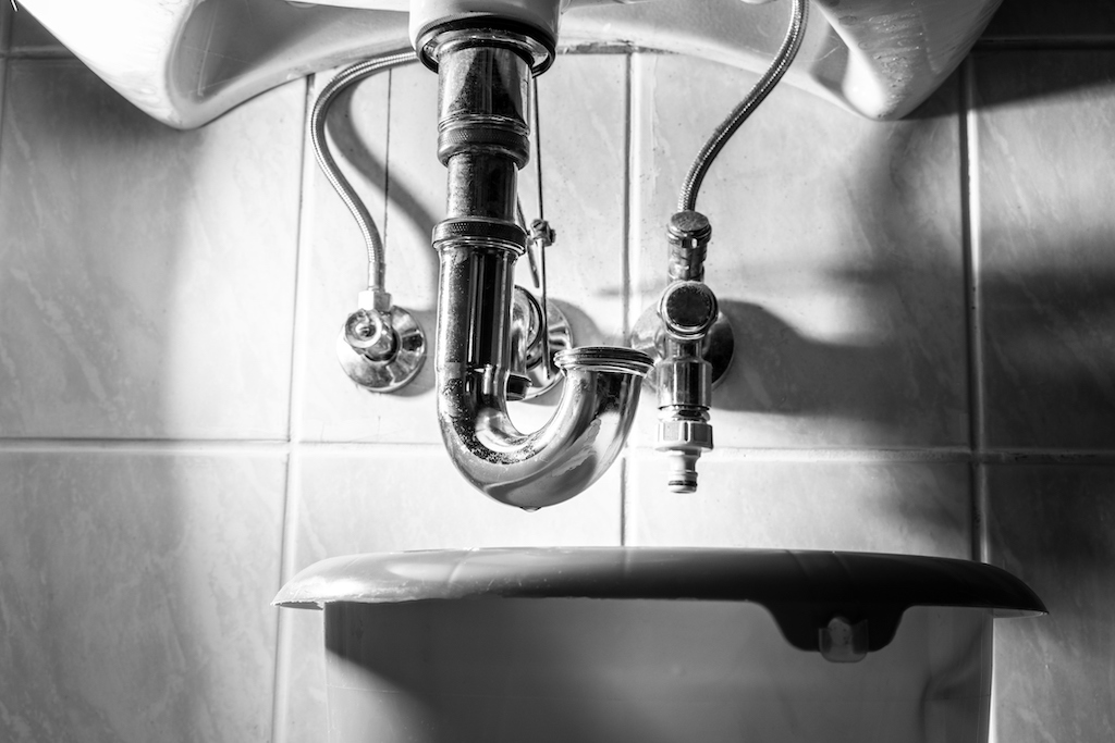 Black and white photo of clogged sink drain in need of plumbing services.