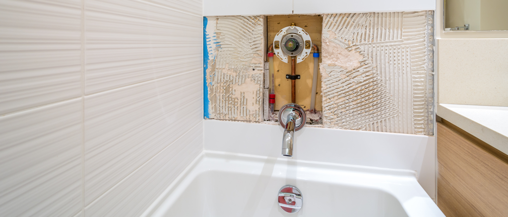 bathtub and shower plumbing fixture repair in a neutral colored bathroom | Plumbing Service in Jesuit Bend, LA