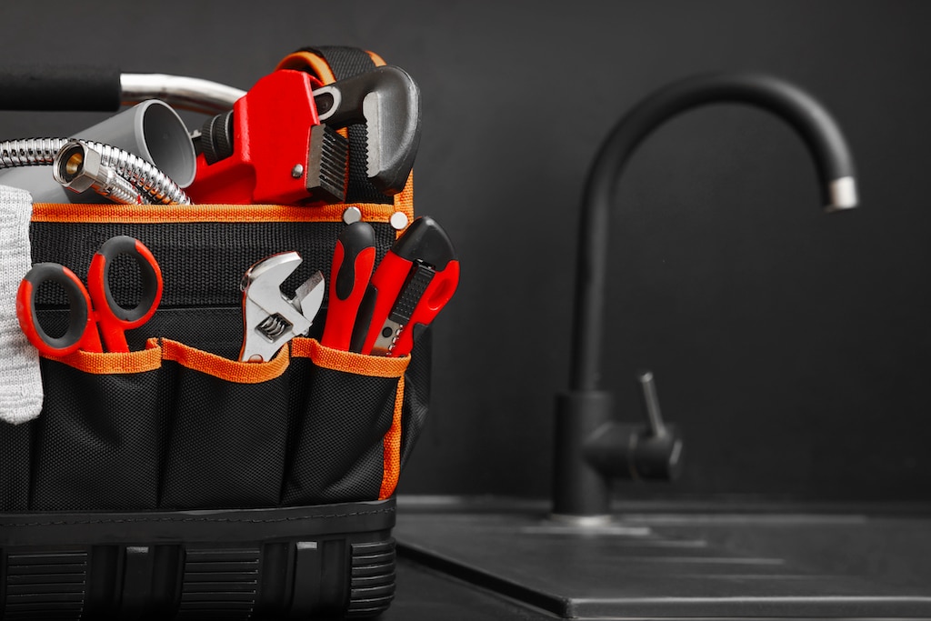 Plumbing tools in a bag on kitchen counter. | Plumbing service