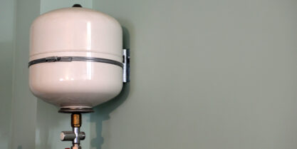 Close up of water Heater Expansion Tank on plain wall.